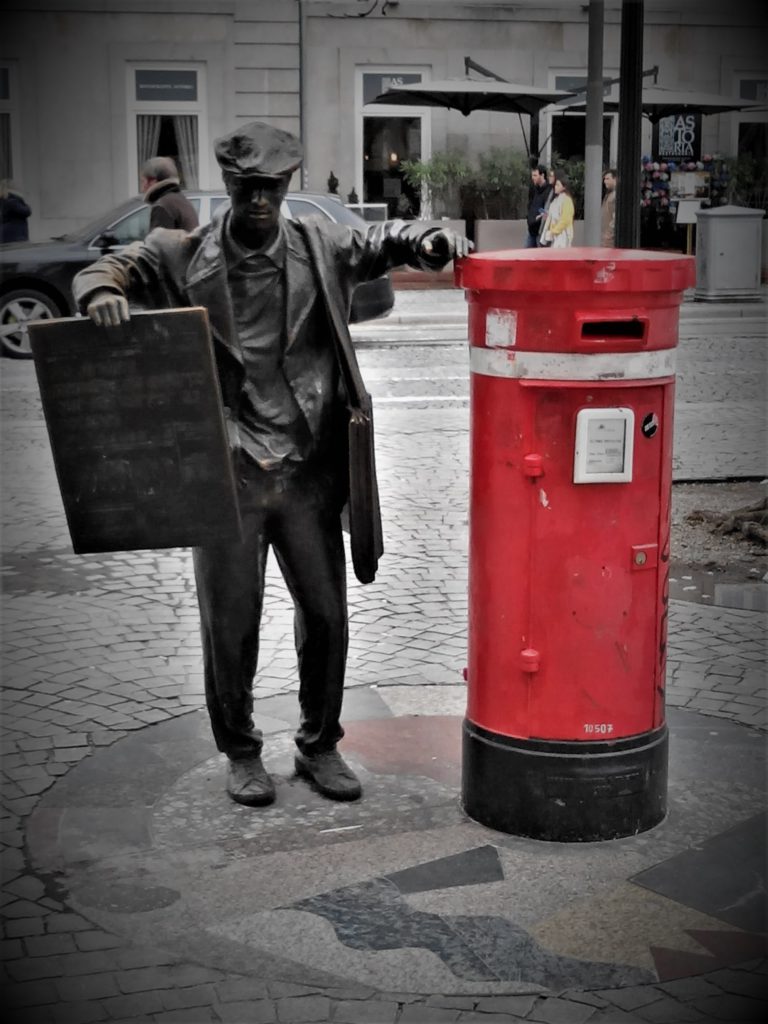 Sculpyire d'un homme près d'une boîte aux lettres