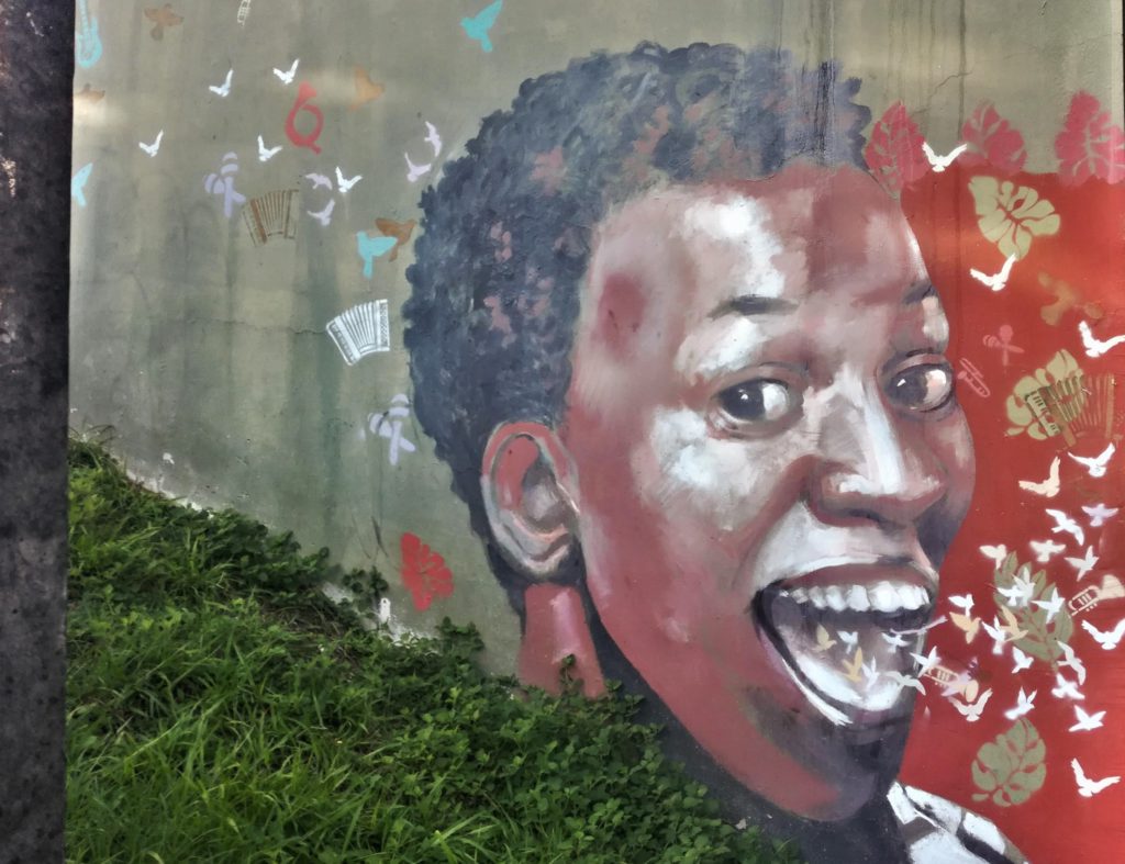 Oeuvre street art représentant un jeune homme avec des oiseaux sortant de sa bouche