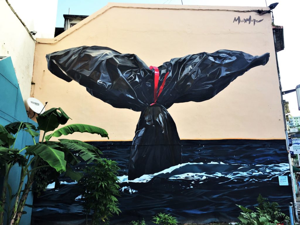 Oeuvre street art présentant la queue d'une baleine en sac plastique