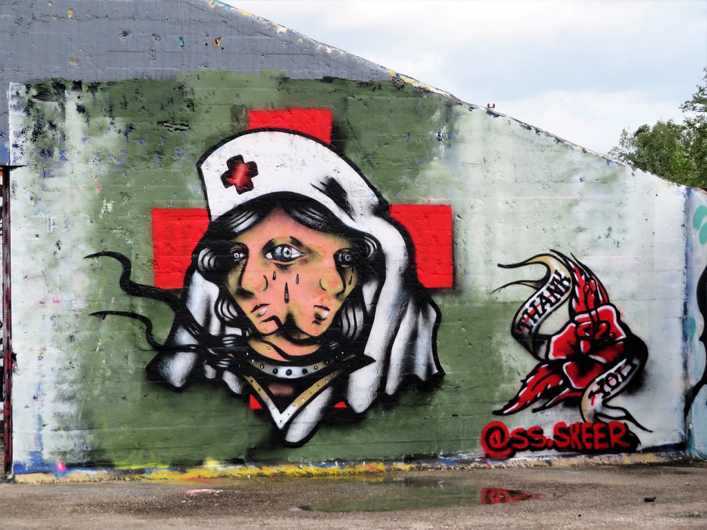 Photo d'un personnel soignant au double visage versant des larmes (street art)